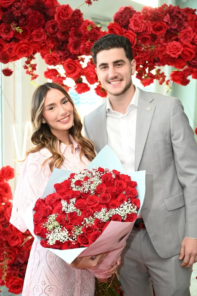 Smiling with an armful of red roses