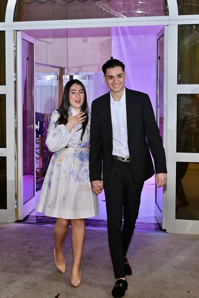 The couple walking out together, smiling